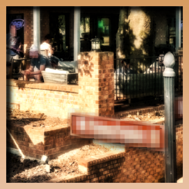 A bloom distorted street corner. The street sign is pixelated beyond recognition.